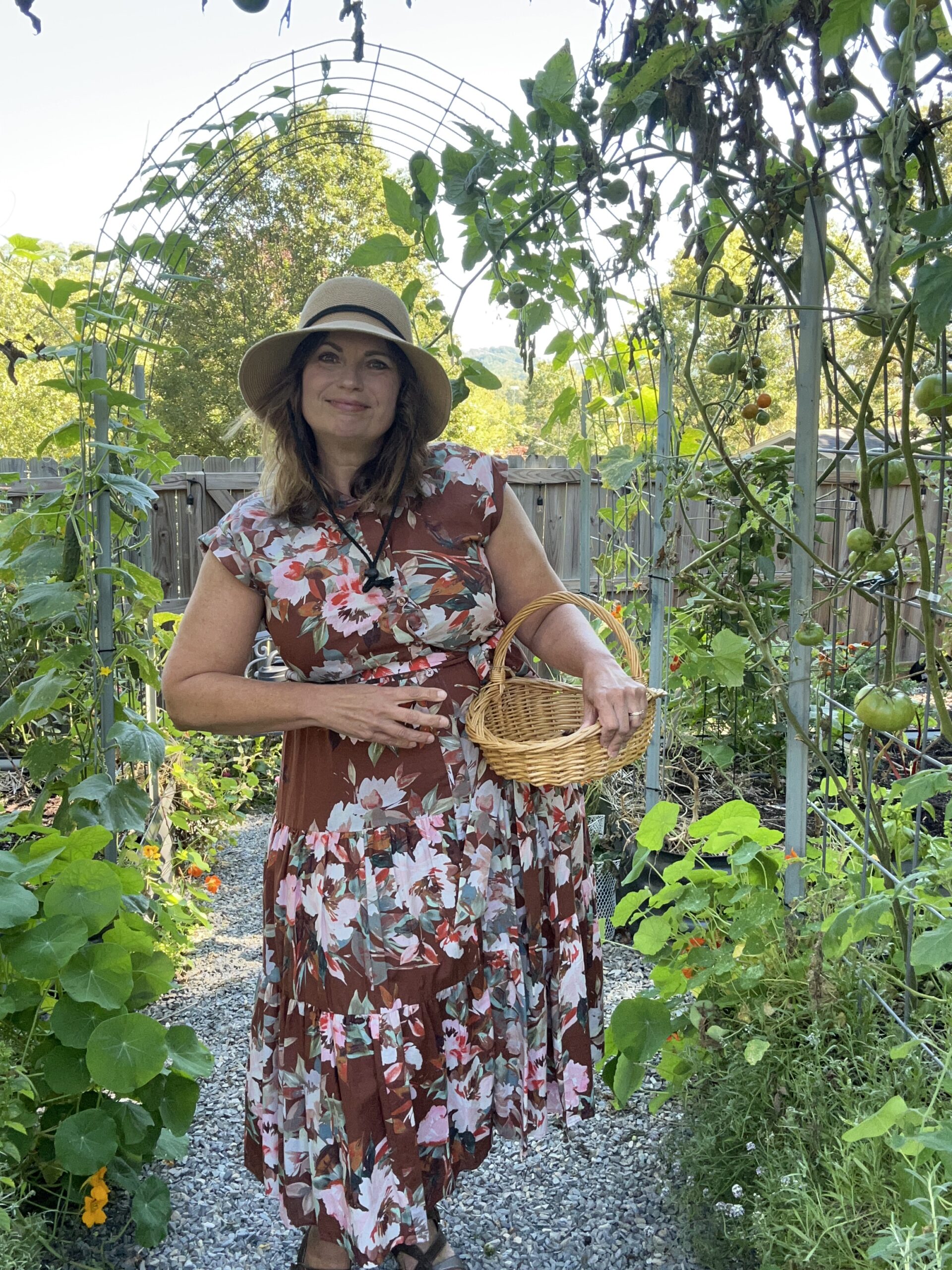 Michelle from Michelle's Garden Grows in garden wearing a brown floral dress and hat