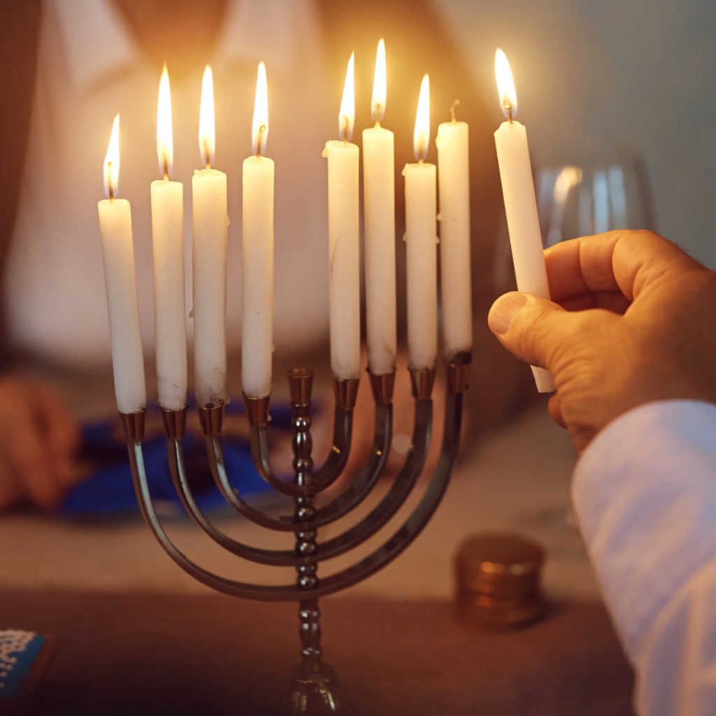 Hanukkah Menorah and candles being lit.