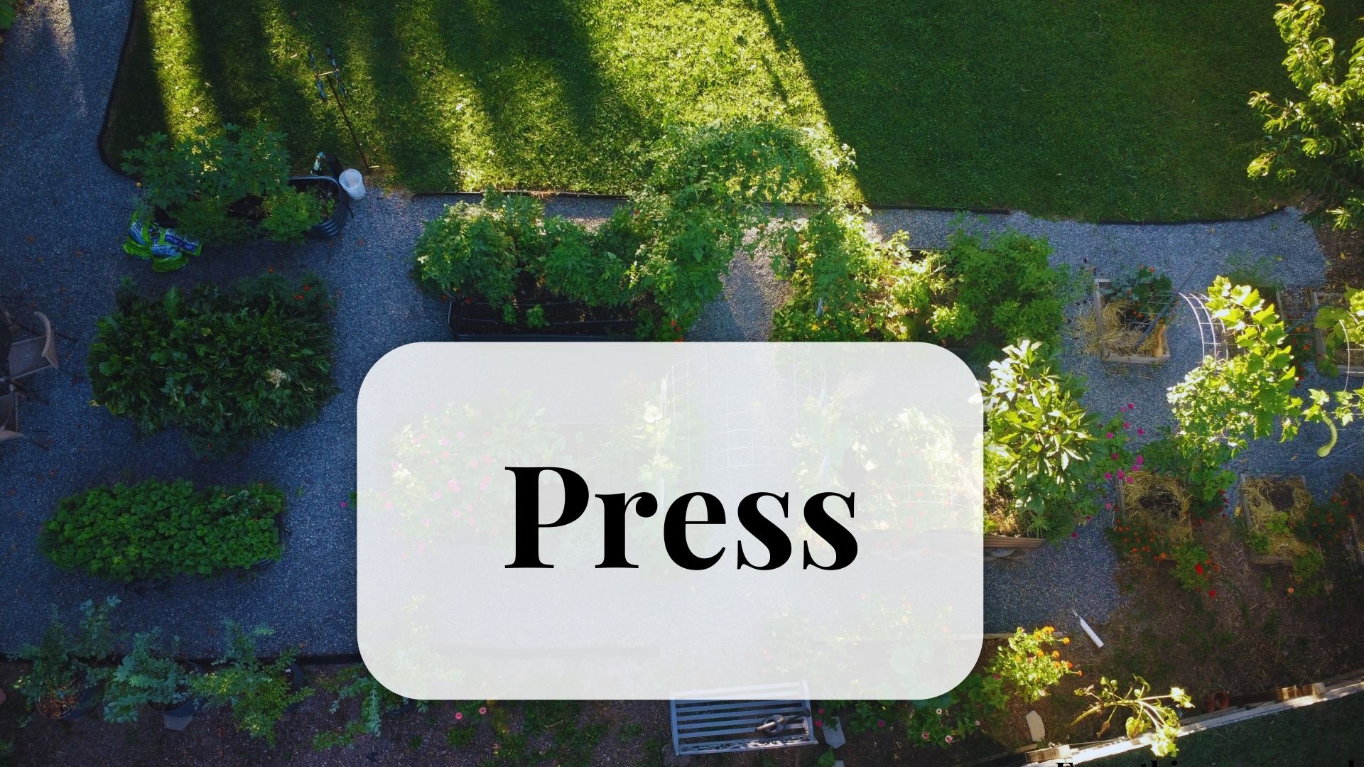 Ariel view of a garden with raised metal beds and trellises.