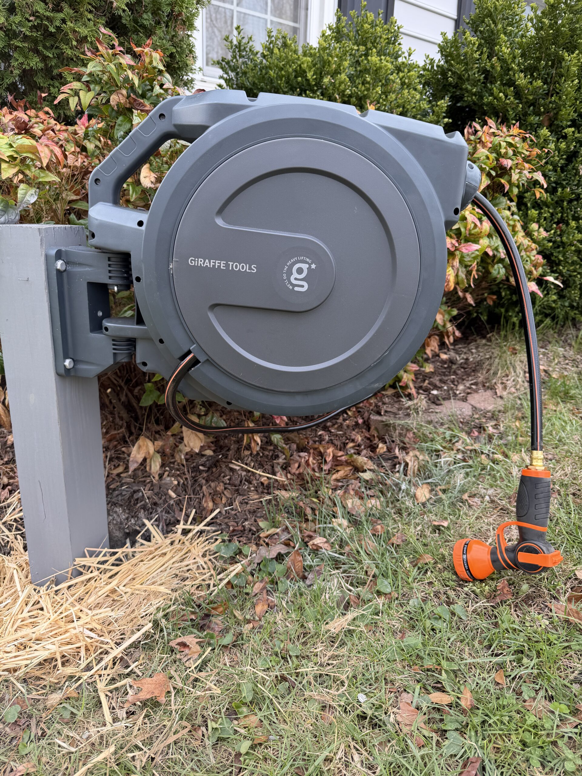 Giraffe Tools Hose Reel mounted on a gray post.