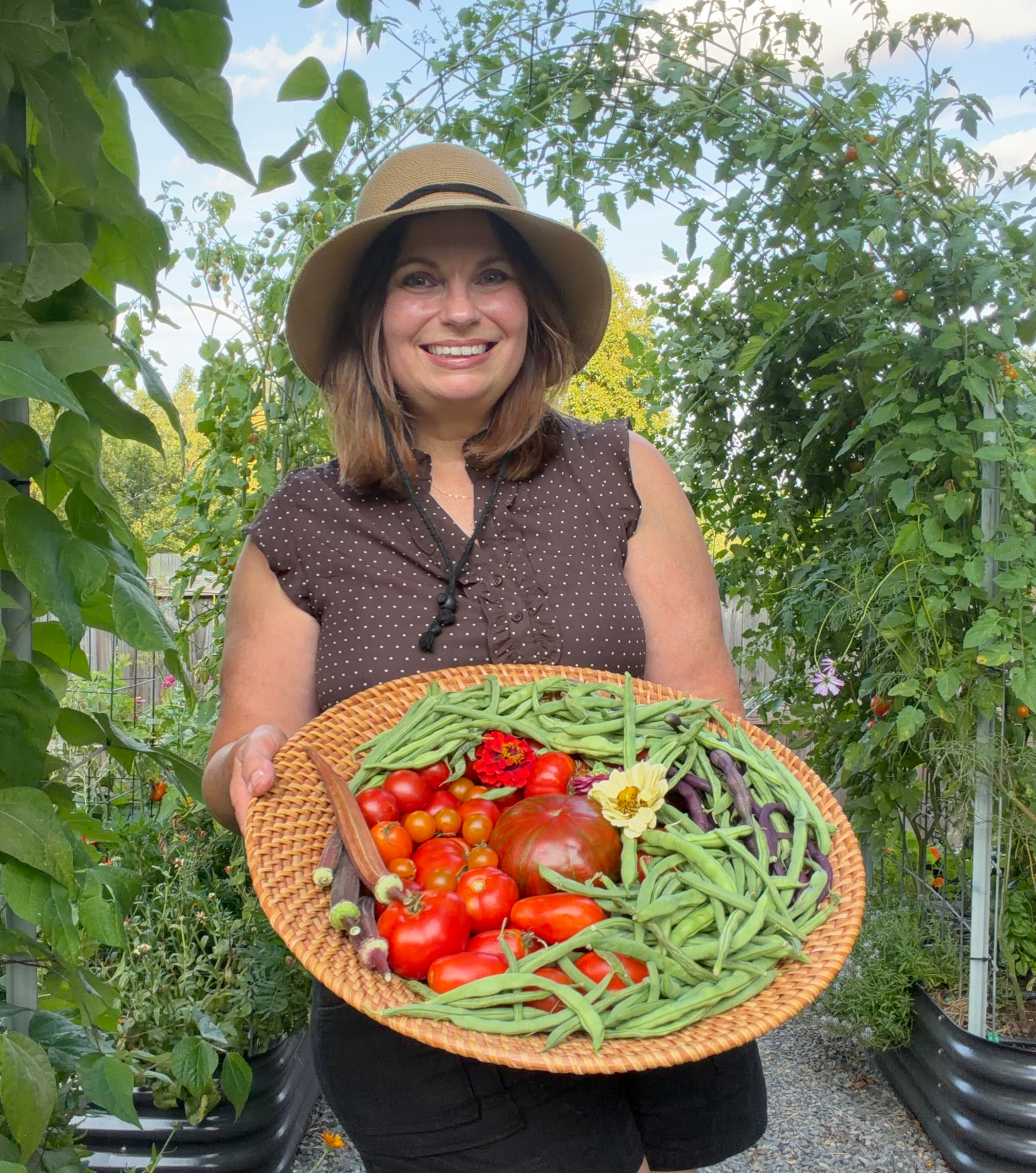 Michelle's Garden Grows holding a harvest basket filled with vegetables